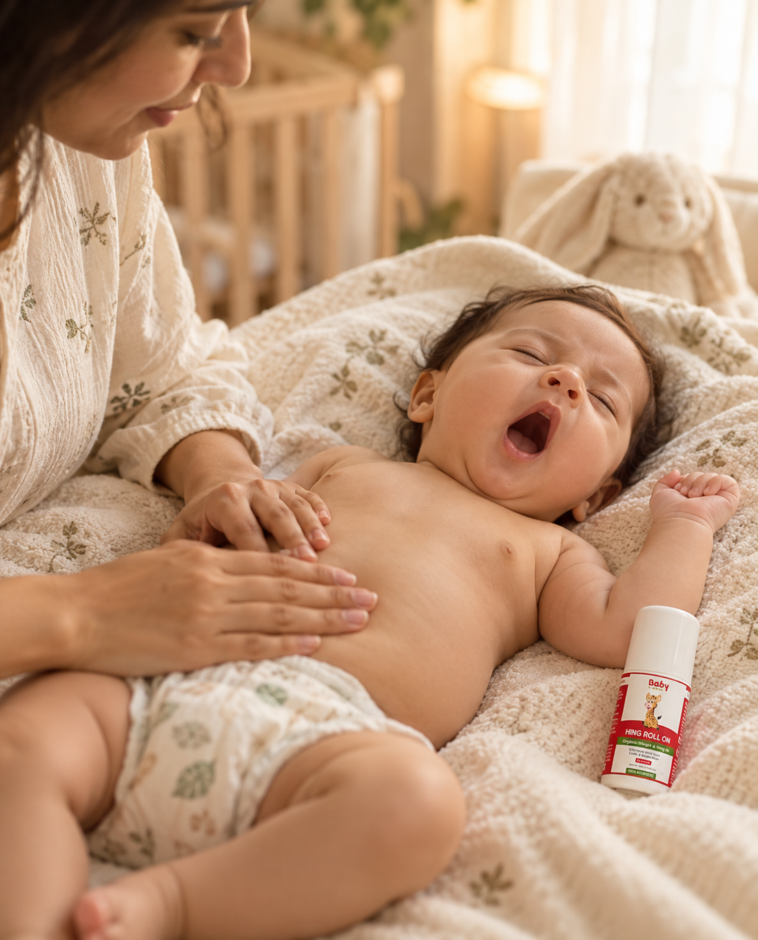 Sleepy baby yawning next to ayurvedic hing tummy roll-on for colic and gas relief