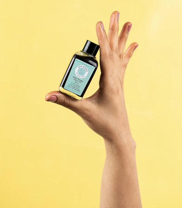 a hand holding the bottle of Intense Scalp therapy oil 