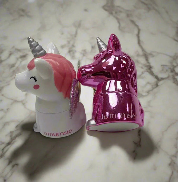 O'mumsie unicorn-shaped lip balm jars for kids in pink and white designs on a marble surface