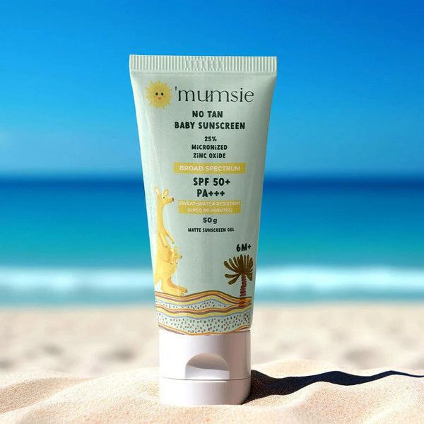 O'mumsie mineral UV-block baby sunscreen with 25% micronized zinc oxide, SPF 50+, shown on a sunny beach