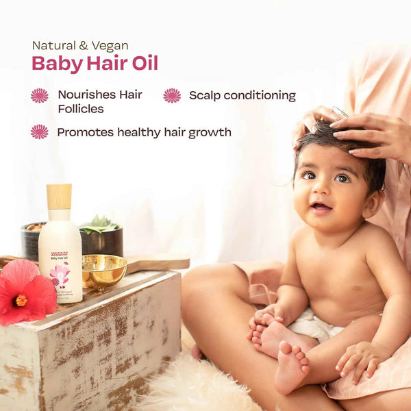 Mother massaging baby's scalp with Maate Baby Hair Oil, natural vegan formula that nourishes hair follicles, conditions scalp, and promotes healthy hair growth