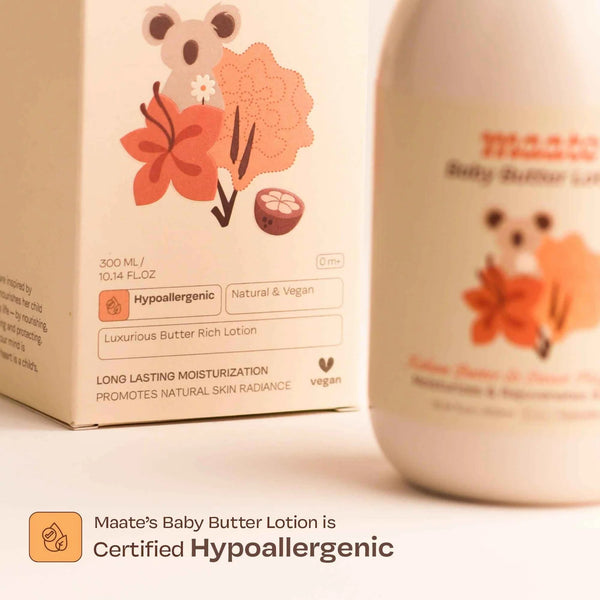 Close-up of Maate Baby Butter Lotion packaging and bottle showing certified hypoallergenic badge, natural and vegan, long lasting moisturization
